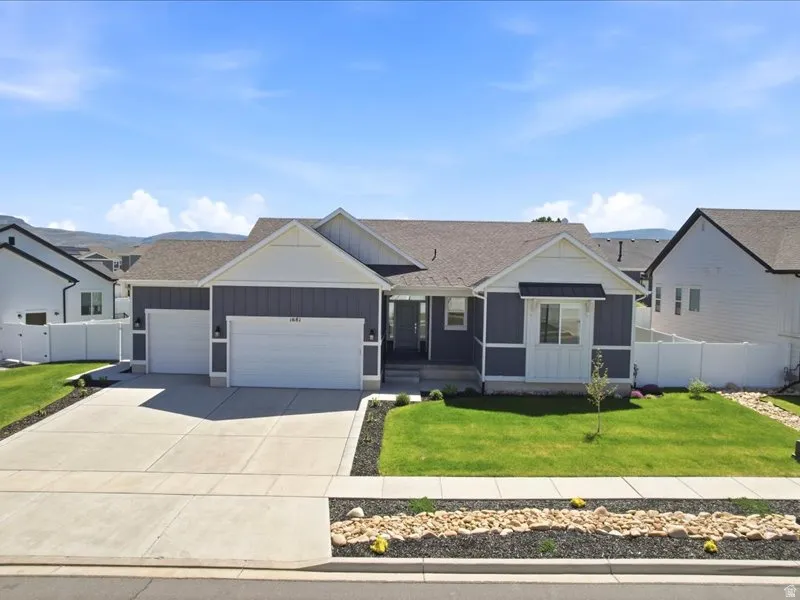 Modern ranch-style home featuring a two-car garage, gray siding, and white trim