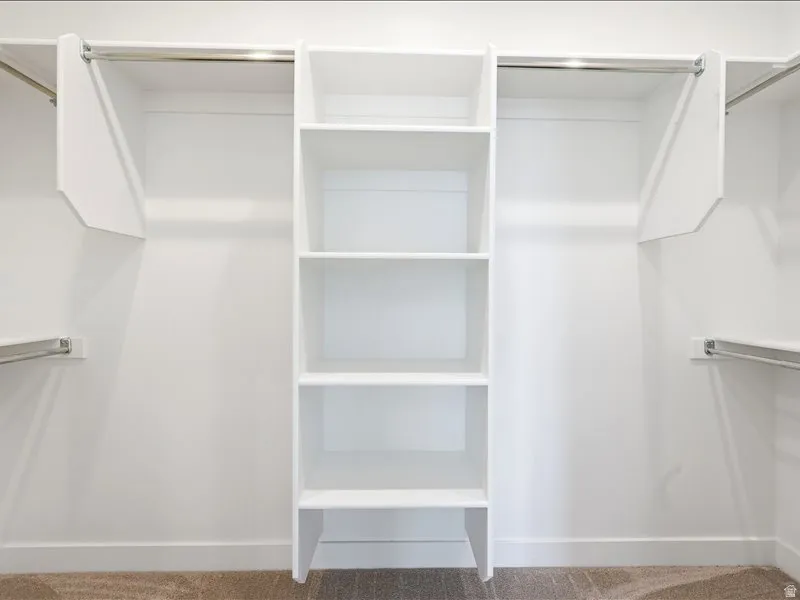 Built-in closet organization system featuring white shelving and chrome hanging rods