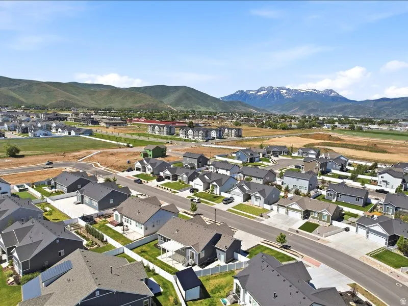 Aerial perspective showcasing a developed residential community with diverse single-family homes and mountain backdrops