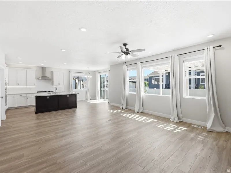 Open-concept living space featuring wood-finish flooring, recessed lighting, and a ceiling fan