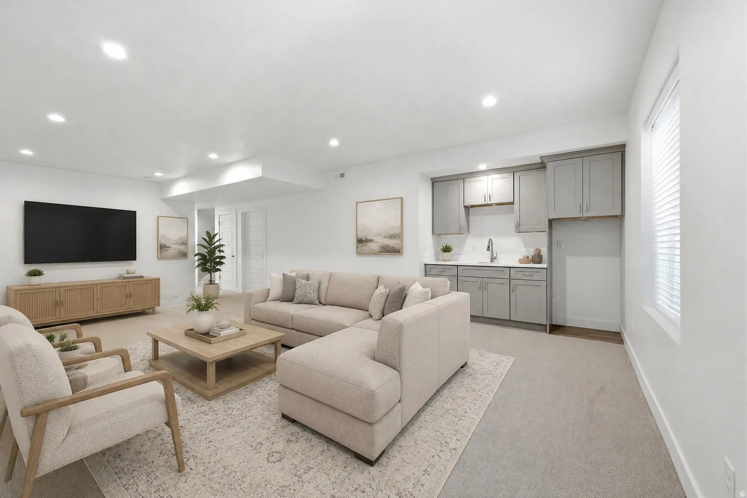 Spacious entertainment area featuring recessed lighting, light gray cabinetry, a white tile backsplash, a sink with a chrome faucet, and a large window with blinds