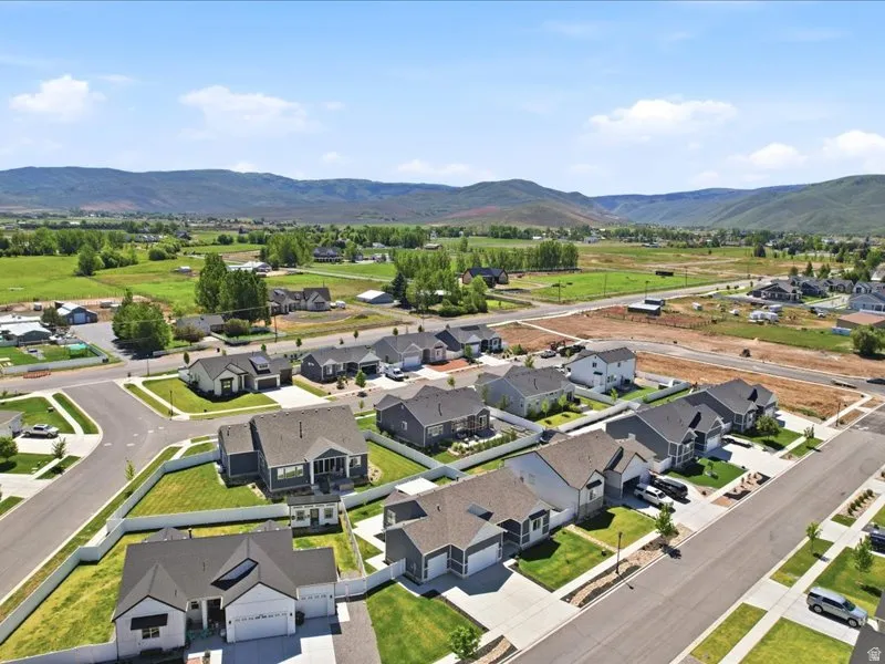 Residential neighborhood featuring a mix of single-family homes with gray and white exteriors, asphalt shingle roofs, and attached garages