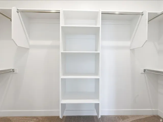 Built-in closet organization system featuring white shelving and chrome hanging rods