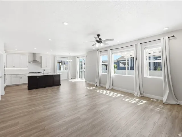 Open-concept living space featuring wood-finish flooring, recessed lighting, and a ceiling fan