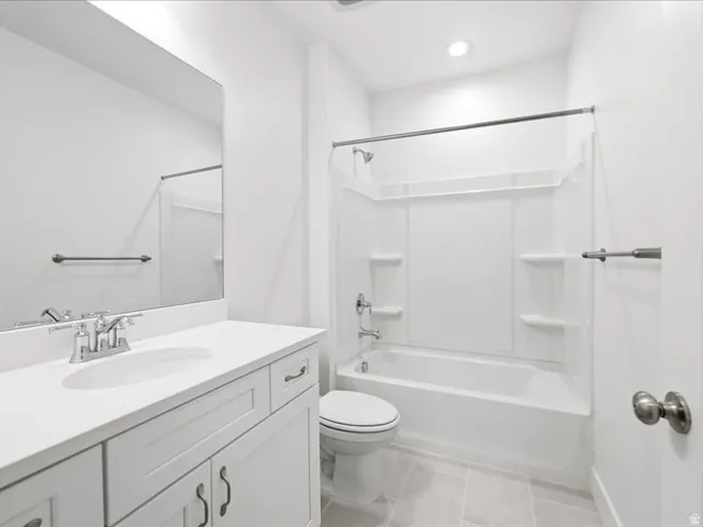 White bathroom featuring a single vanity with an integrated sink, polished chrome faucet, and white cabinet doors with dark hardware