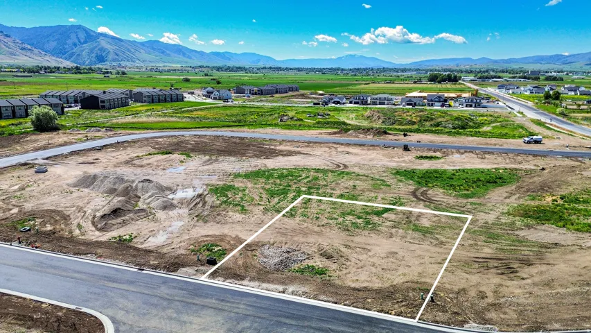 Cleared parcel of land with a defined boundary, bordered by newly paved roads