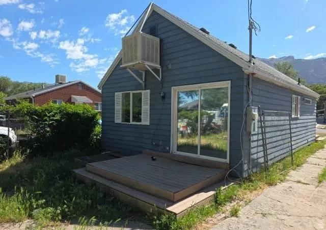 Rear exterior featuring blue siding, white sliding glass door, multi-level composite deck, and white window shutters