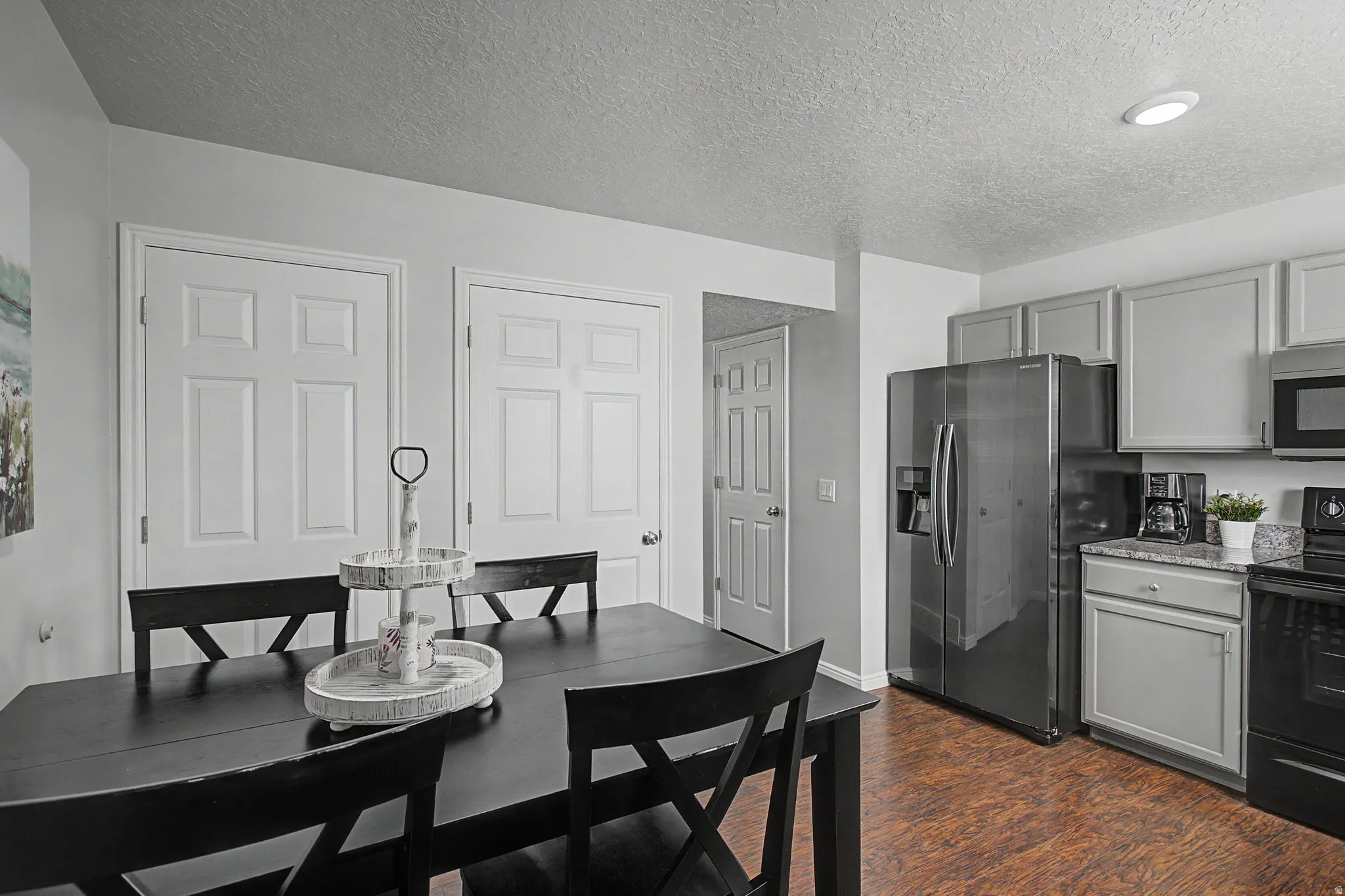 Kitchen area featuring stainless steel appliances, light gray cabinetry, and stone-look countertops