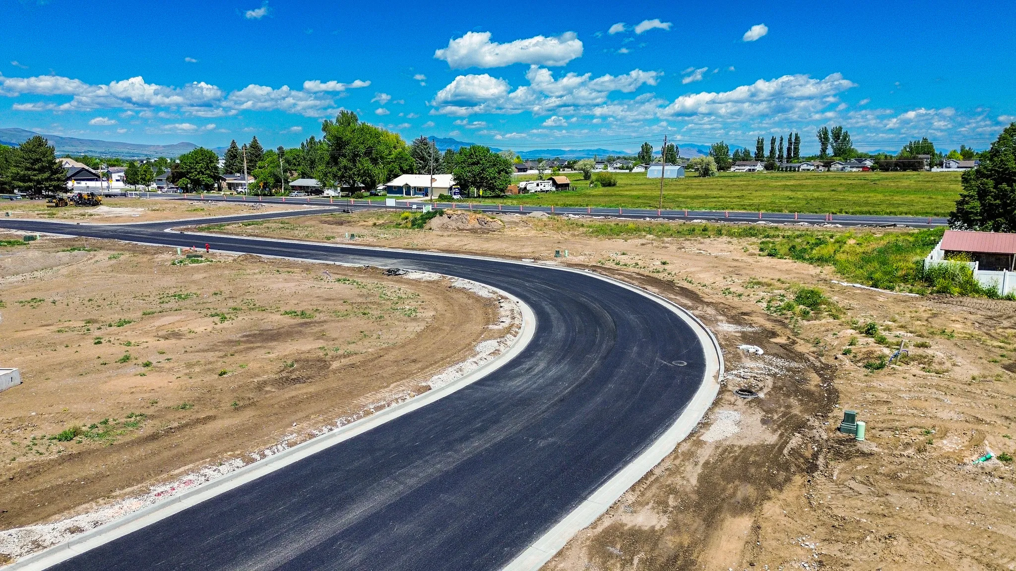 Newly paved asphalt road with concrete curbing