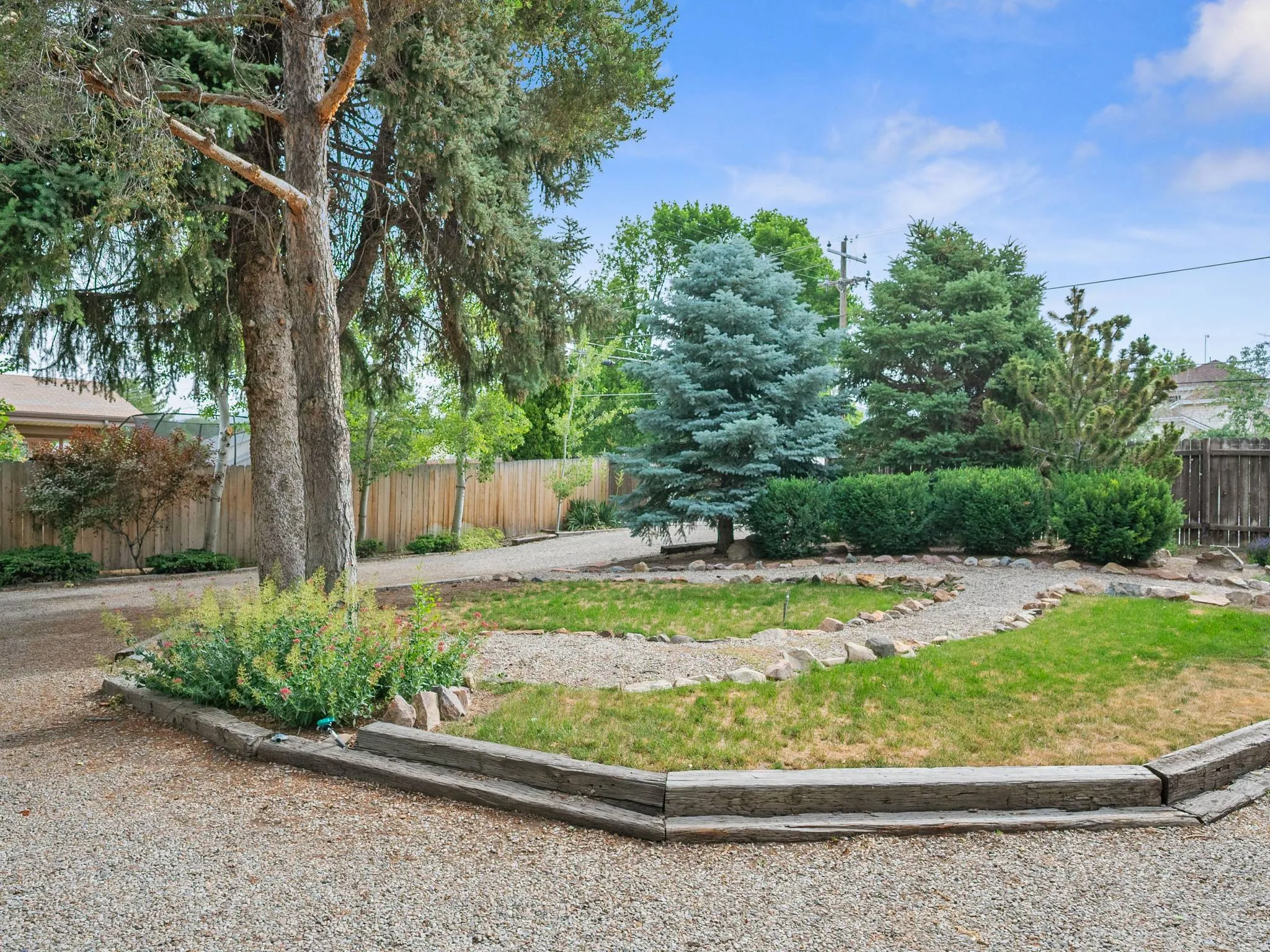 Circular gravel driveway with mature trees, established shrubs and trees decorative stone pathway