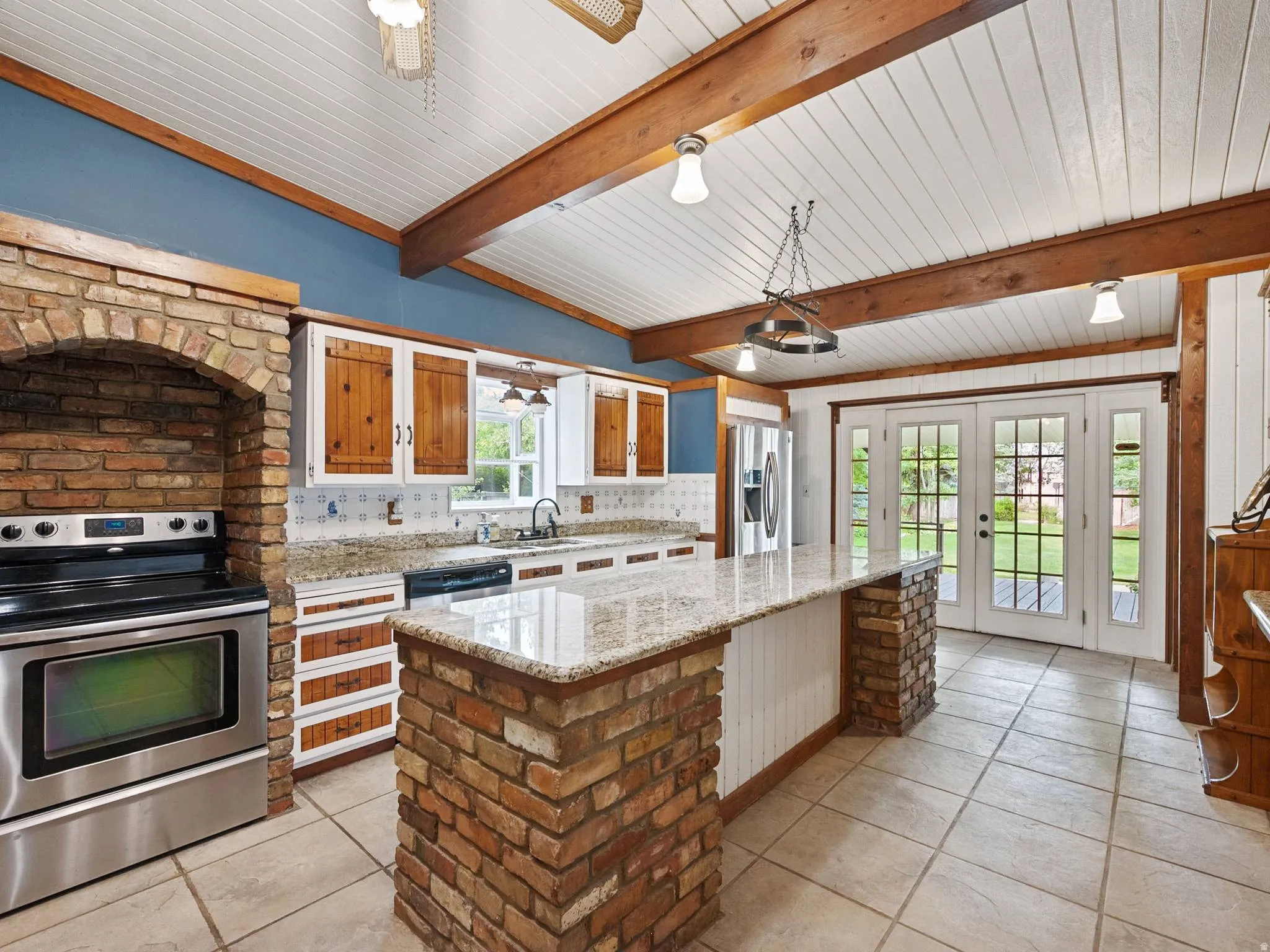 Another view of the kitchen featuring a brick archway surrounding the stainless steel range