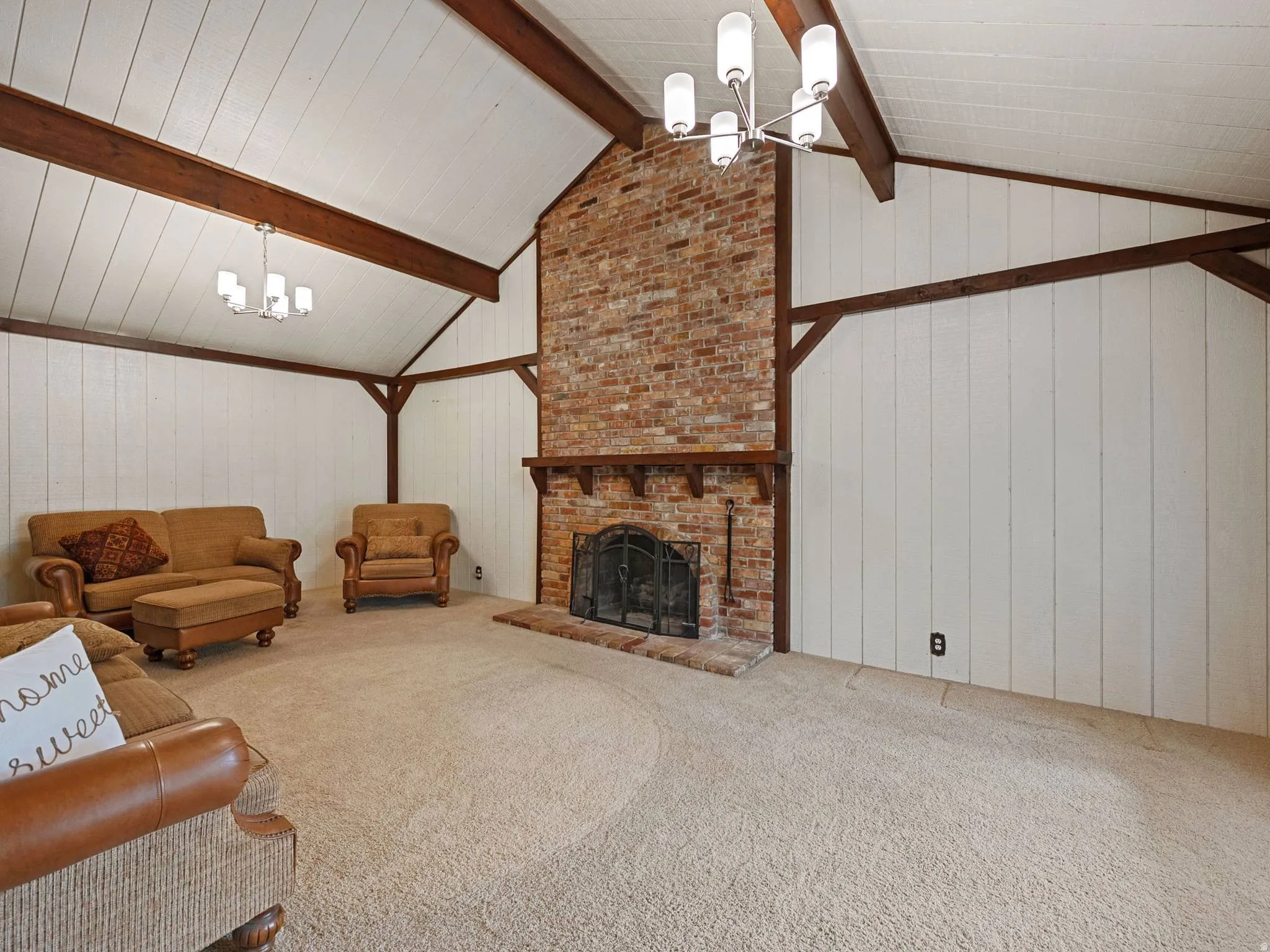 Large Main Living Room with vaulted ceiling with exposed wood beams and white paneling