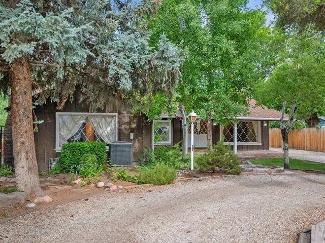 Exterior featuring a gravel driveway, mature trees