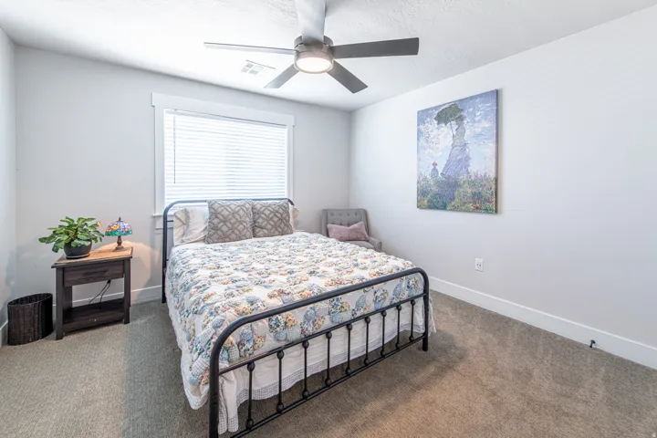 Carpeted room featuring a ceiling fan with integrated lighting, a window with blinds, and white baseboards
