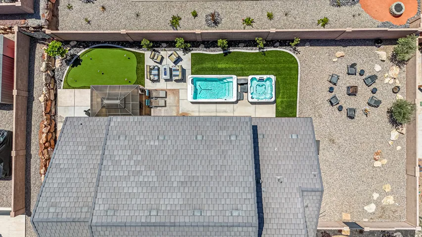 Expansive backyard featuring a putting green, inground swim spa, and separate hot tub