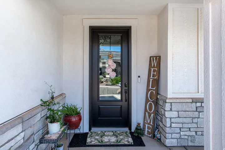 Entryway featuring a black door with decorative glass, white trim, and a stone veneer wainscoting