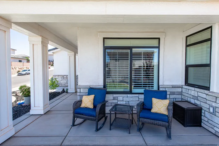 Covered front porch featuring concrete flooring and architectural columns