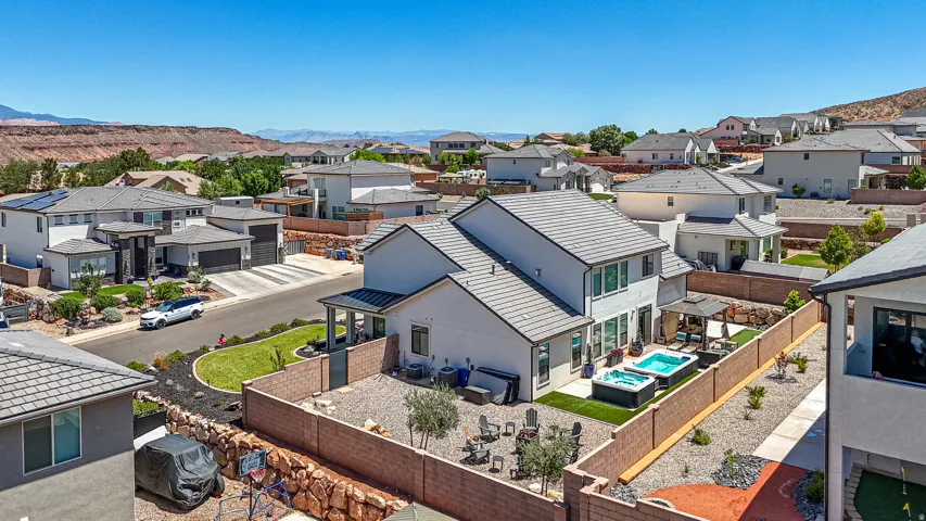 Backyard oasis featuring two hot tubs, a covered patio area, and an artificial turf section