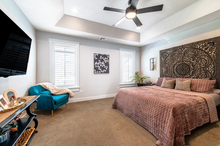 Bedroom featuring a tray ceiling with recessed lighting and a ceiling fan