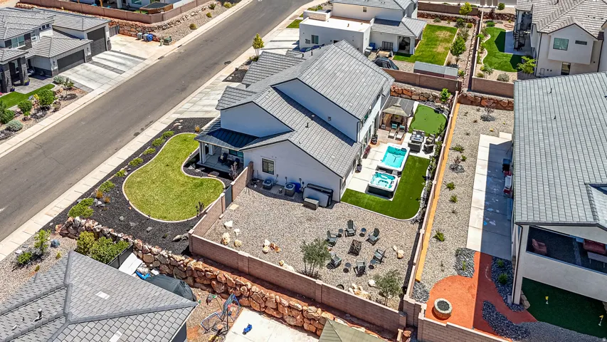 Expansive rear yard featuring an in-ground pool, separate spa, and artificial turf