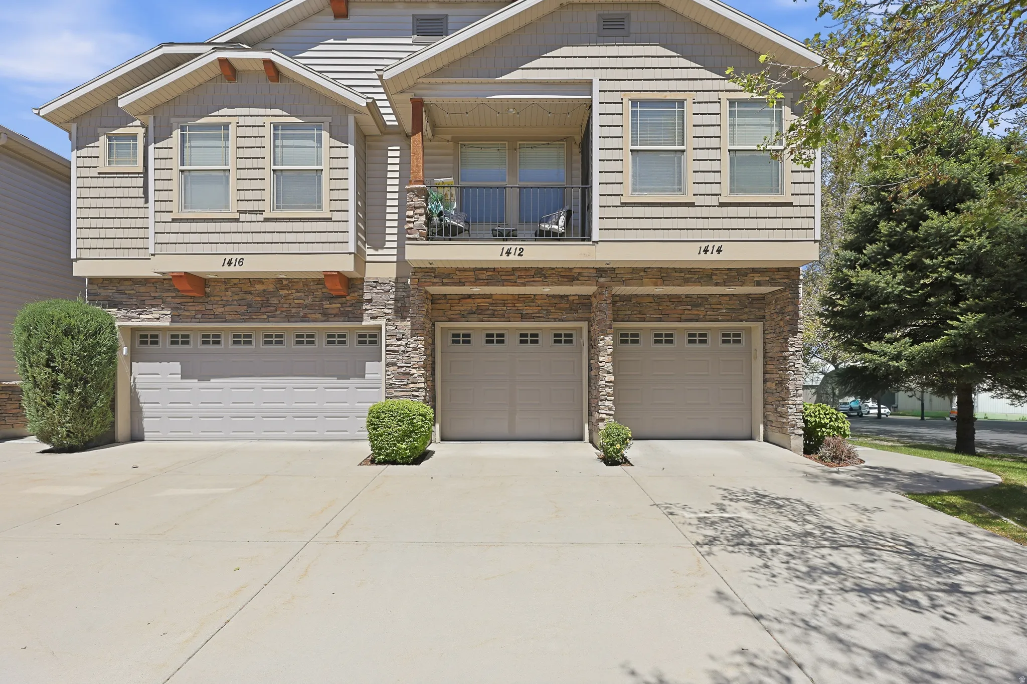Multi-level townhouse exterior featuring stacked stone and horizontal siding