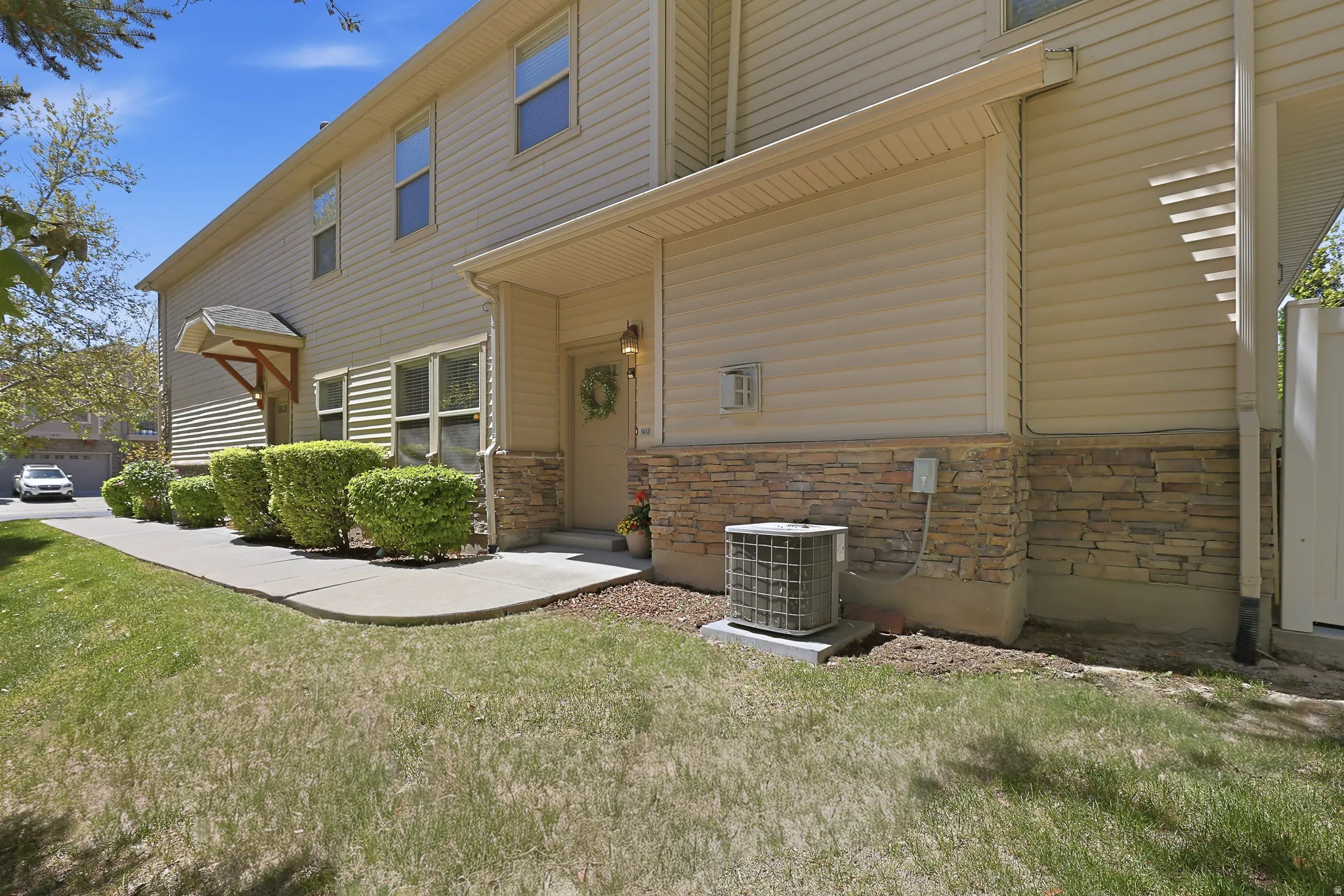 Exterior featuring light-toned horizontal siding and a stone veneer foundation