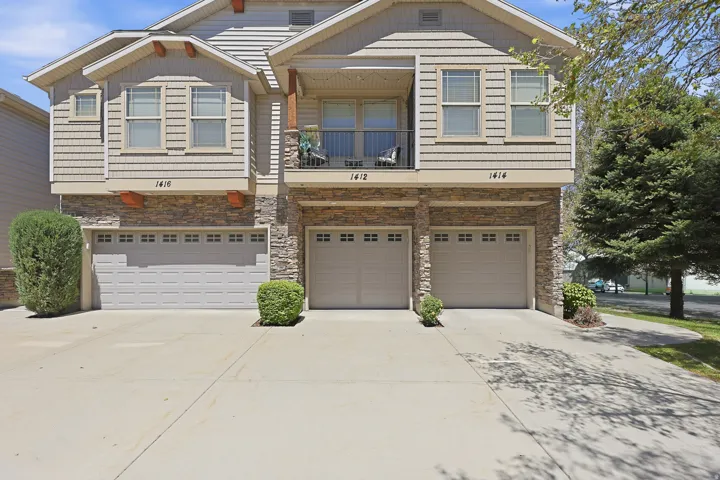 Multi-level townhouse exterior featuring stacked stone and horizontal siding