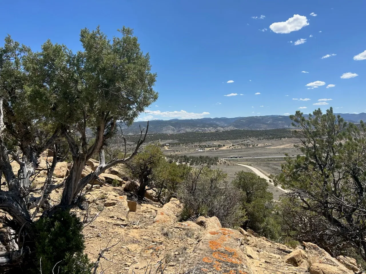 Expansive natural landscape featuring rugged terrain and distant mountain ranges