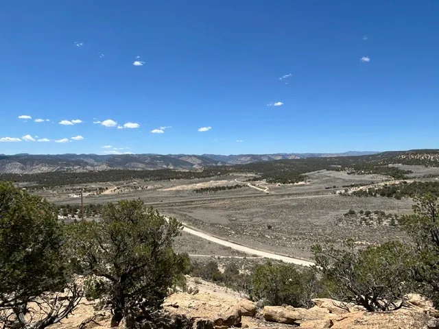 Expansive land parcel featuring distant mountain ranges and a clear blue sky