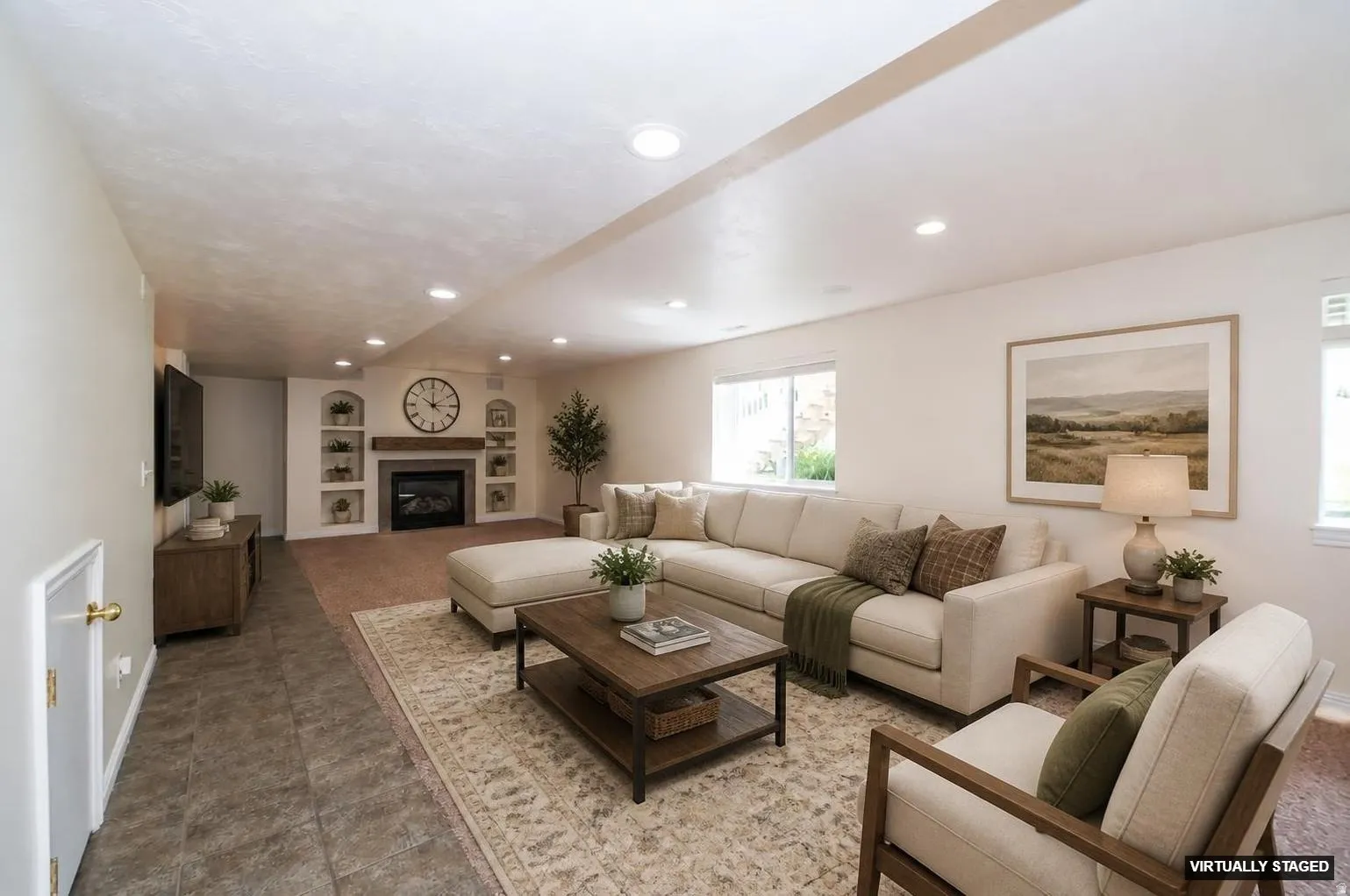 Recessed lighting illuminates this living space, featuring a fireplace with a wood mantel, built-in shelving, and large windows