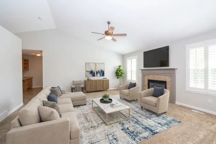 Vaulted ceilings, a built-in fireplace with a stone surround, and plantation shutters