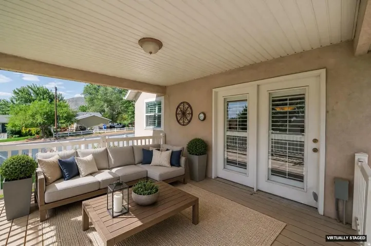 Covered outdoor patio featuring white wood-finish decking, a paneled ceiling, and double glass-paneled doors