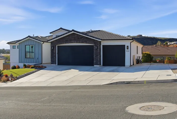 Contemporary residence featuring a multi-tone exterior with dark stone accents