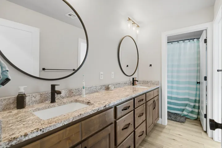 Double vanity with stone countertop, undermount sinks, and matte black fixtures