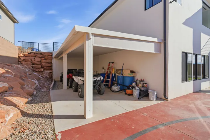 Covered parking structure with two bays, integrated into the building's white stucco exterior