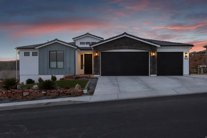 Contemporary exterior featuring a stone and siding facade with a two-car garage