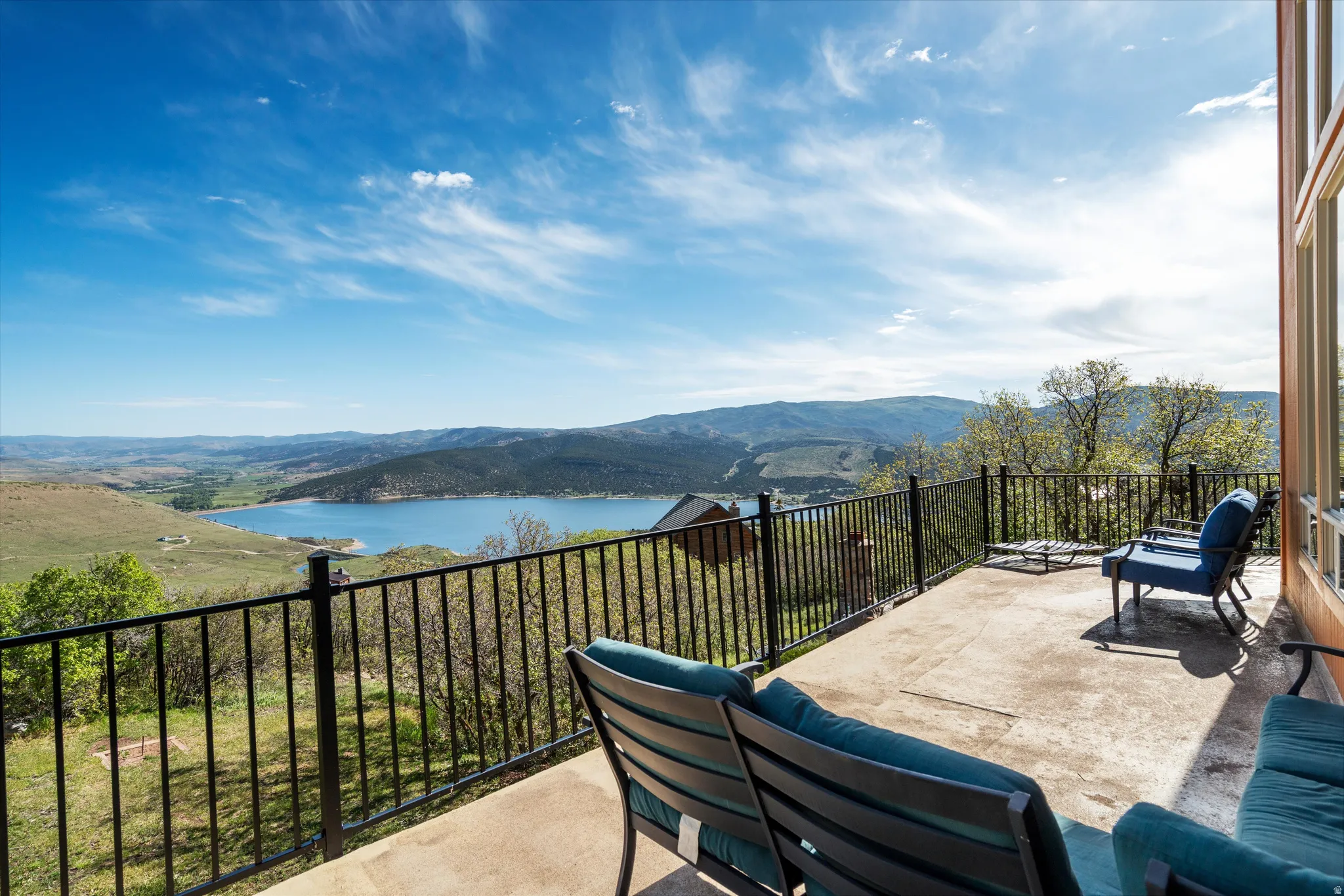 Concrete patio featuring a black metal railing and expansive water and mountain scenery