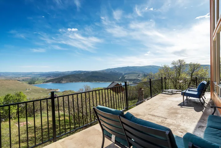 Concrete patio featuring a black metal railing and expansive water and mountain scenery