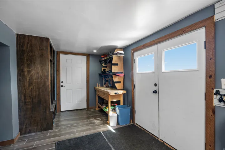 Entryway featuring double doors with transom windows, wood-finish flooring, and a built-in storage unit