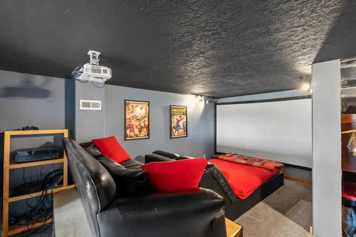 Dedicated media room featuring a large projection screen and ceiling-mounted projector