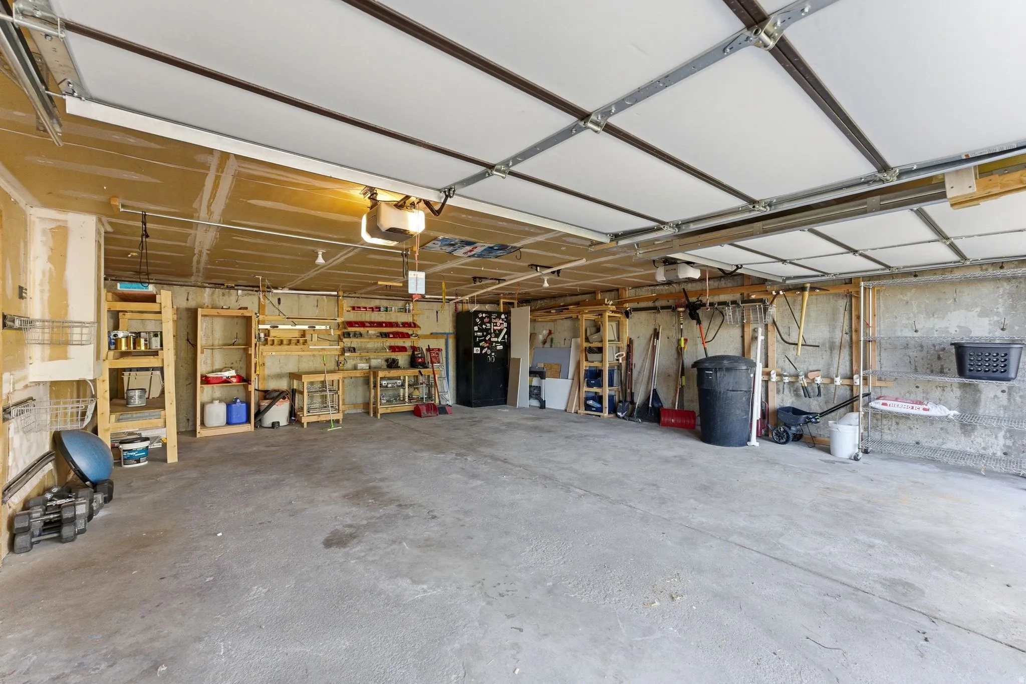 Spacious garage featuring built in shelves and workbench