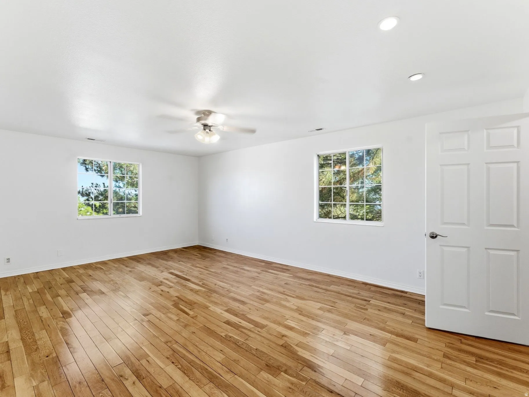 Spacious primary suite with hardwood floors.