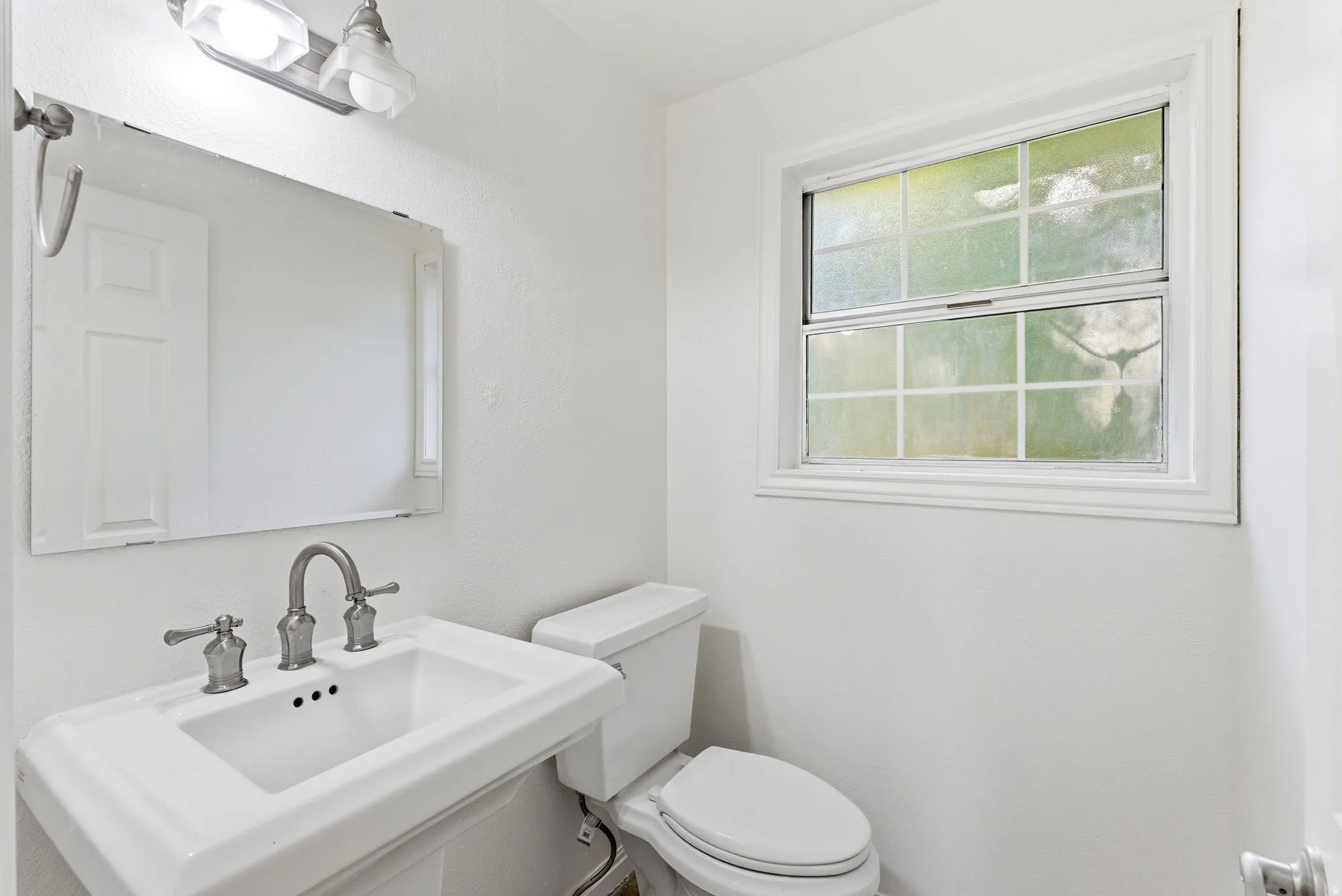 Main level 1/2 bathroom with pedestal sink.
