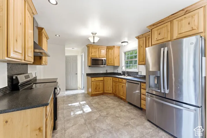 Kitchen featuring Alder wood cabinetry and tile floors. Stainless refrigerator included
