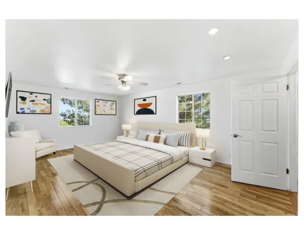 Virtual staged photo - Spacious primary suite  featuring hardwood floors.