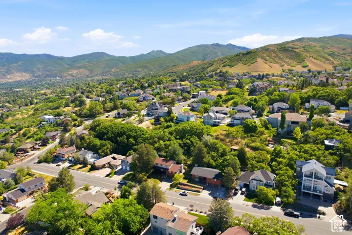 Expansive residential area featuring a variety of architectural styles, mature trees, and mountainous terrain