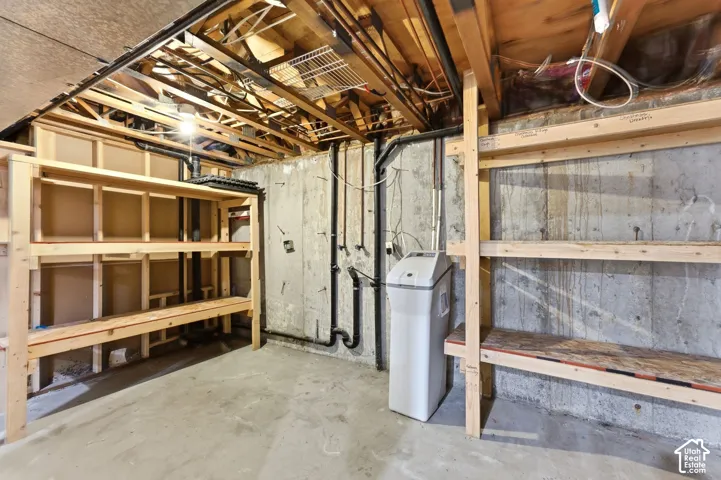 Utility space featuring built in shelves and plumbed for a 2nd laundry room.