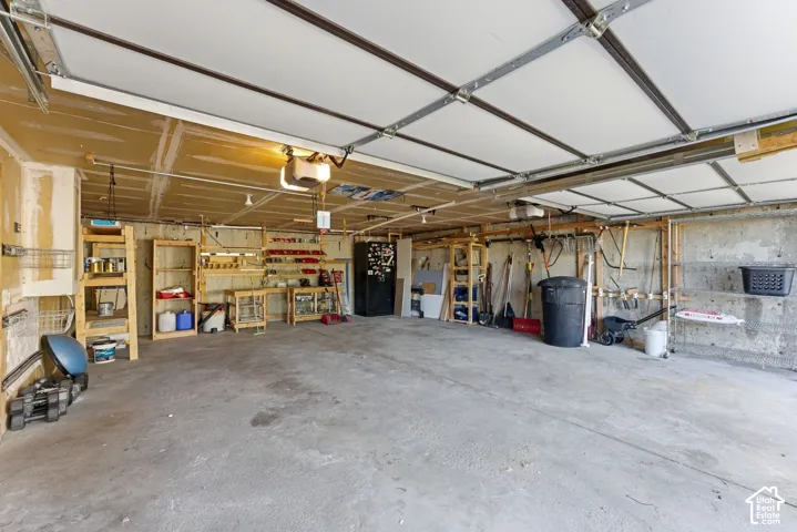 Spacious garage featuring built in shelves and workbench