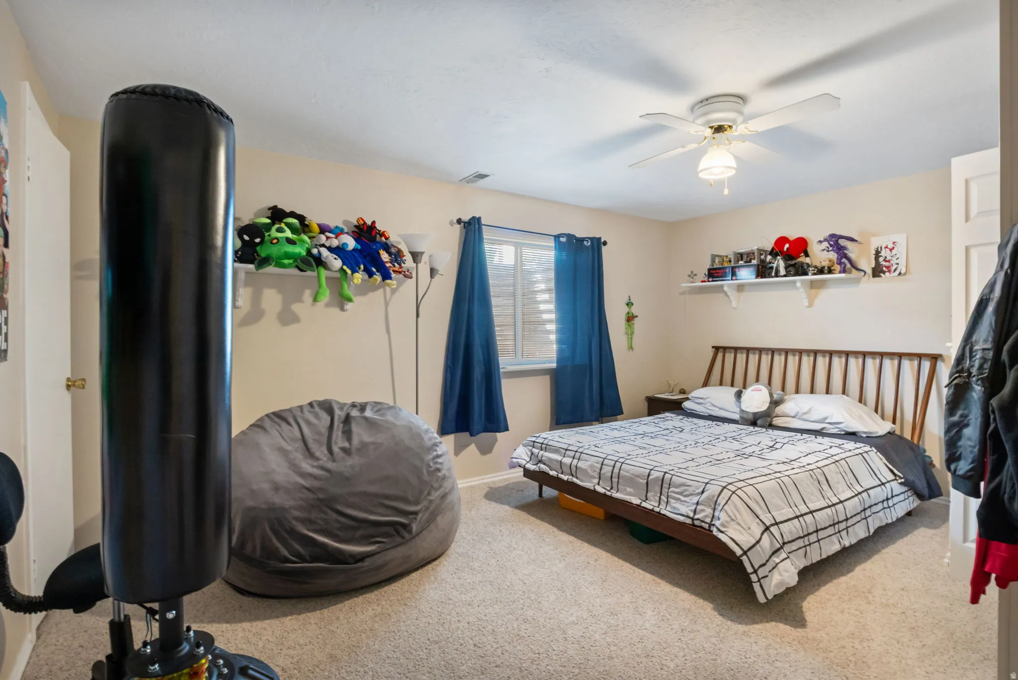 Carpeted room featuring a ceiling fan, window with blinds, and built-in shelving