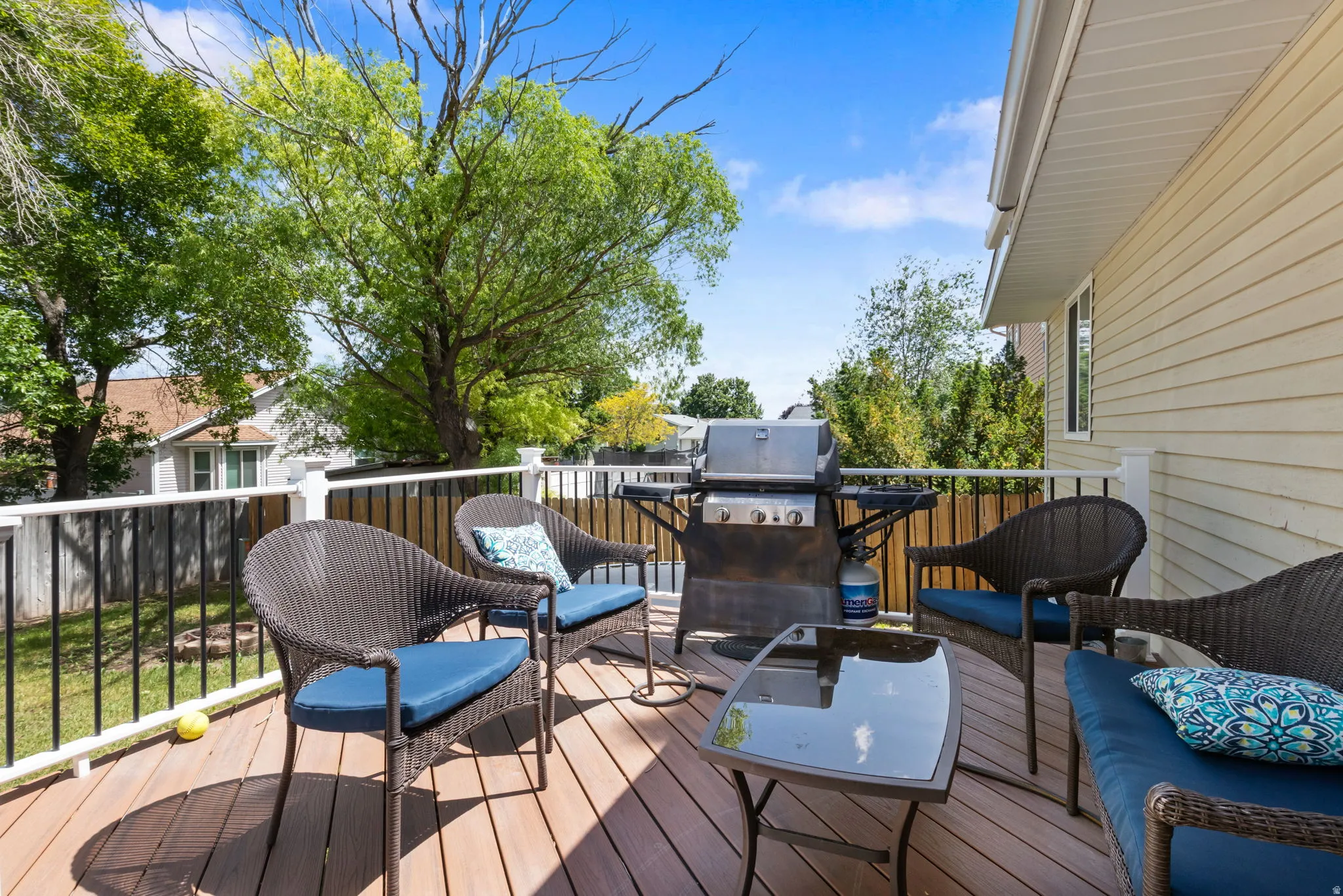 Spacious outdoor deck featuring wood-finish flooring and a white railing with black balusters